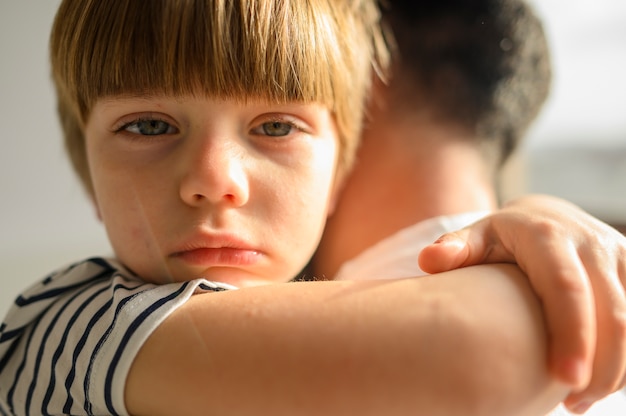 Foto gratuita primer niño abrazando a su padre