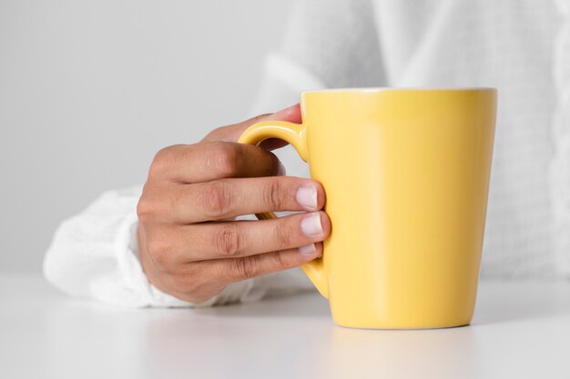 Primer niño sosteniendo una taza amarilla