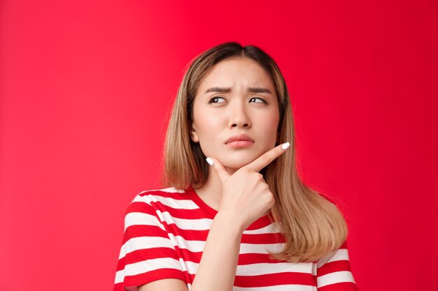 Primer novia pensativa sospechosa reflexionando toque barbilla entrecerrando los ojos dudoso y frunciendo el ceño mirada u ...