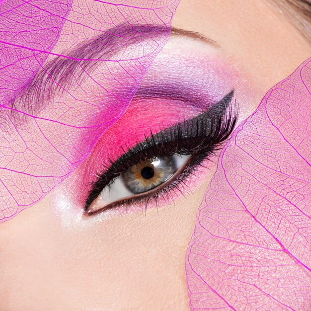 Primer ojo femenino con maquillaje rosa brillante de moda hermosa