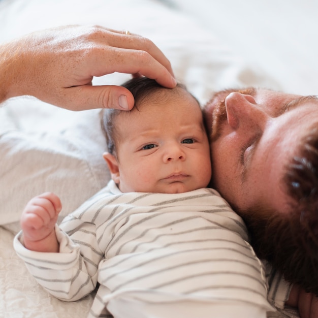 Primer padre sentado cerca de hijo