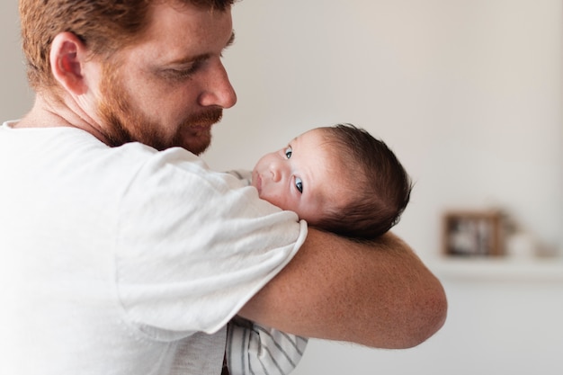 Primer padre sosteniendo bebé con ojos azules