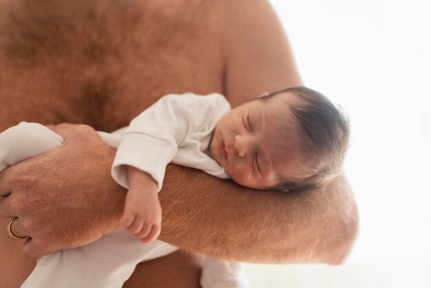 Primer padre sosteniendo bebé con sueño