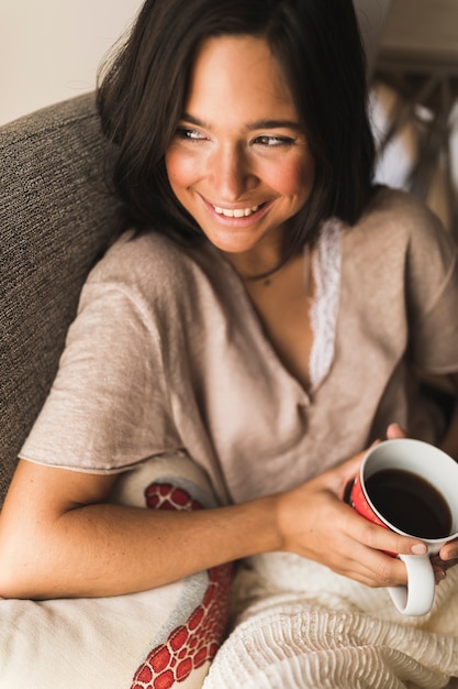 Primer plano de una adolescente sonriente con una taza de café