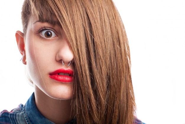 Primer plano de adolescente sorprendida con el pelo sobre la cara