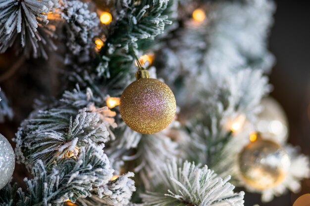 Primer plano de adornos navideños y luces de un árbol de Navidad