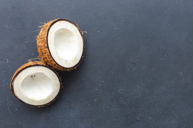 Primer plano aéreo de cocos cortados sobre una mesa gris