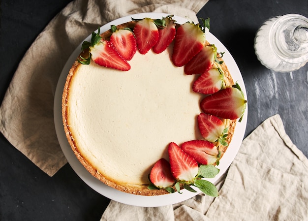 Foto gratuita primer plano aéreo de una tarta de queso con fresas en una placa blanca.