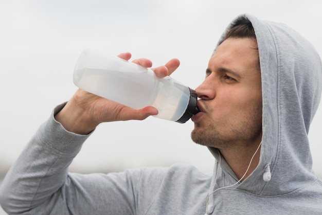 Primer plano de agua potable masculina adulta