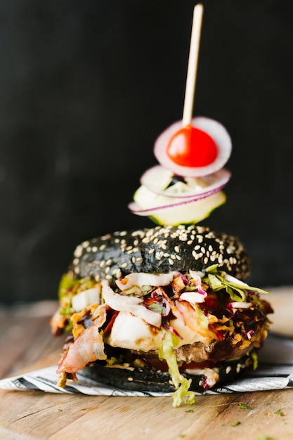 Primer plano de alto ángulo de hamburguesa negra y papas fritas en tablero de madera