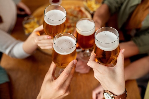 Primer plano de amigos brindando con cerveza