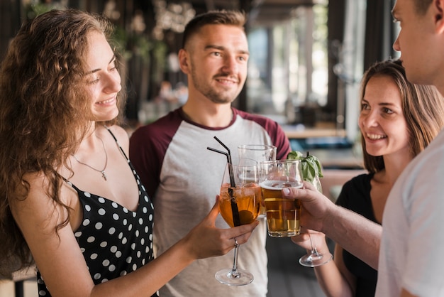 Primer plano de amigos brindando vasos de bebidas