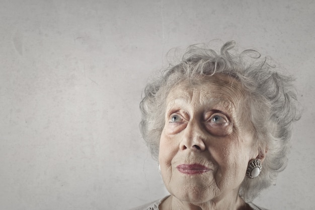 Foto gratuita primer plano de una anciana con ojos azules y cabello gris