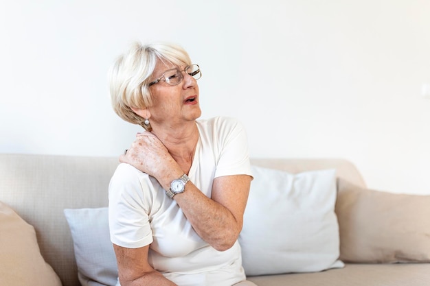 Foto gratuita primer plano de una anciana triste con dolor de cuello mujer mayor con síndrome de dolor crónico fibromialgia que sufre de dolores de cuello agudos mujer mayor que sufre de dolor de cuello