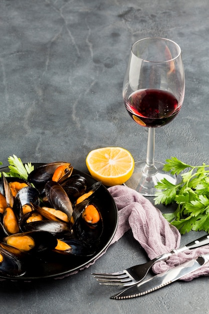 Foto gratuita primer plano de ángulo alto de mejillones cocidos y botella de vino