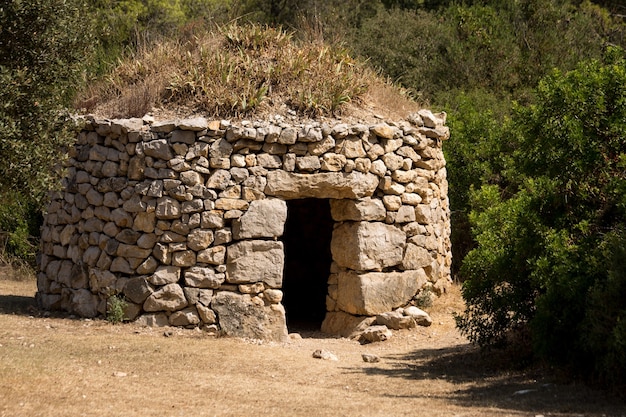 Primer plano de un antiguo refugio de piedra en un bosque