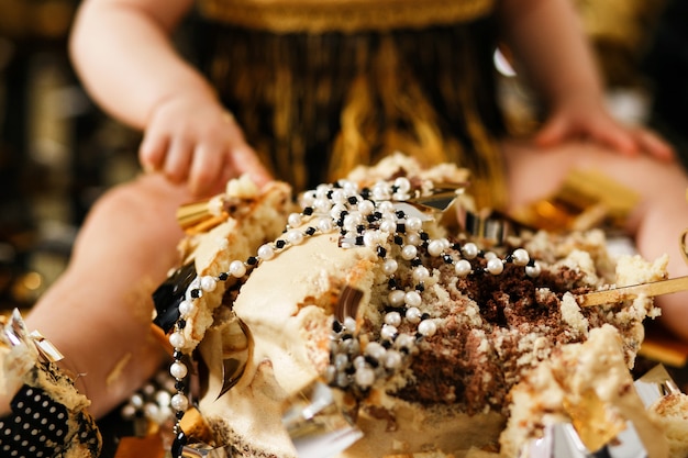 Primer plano aplastado de la torta tirado con joyería de la perla. Primera fiesta de cumpleaños de la niña