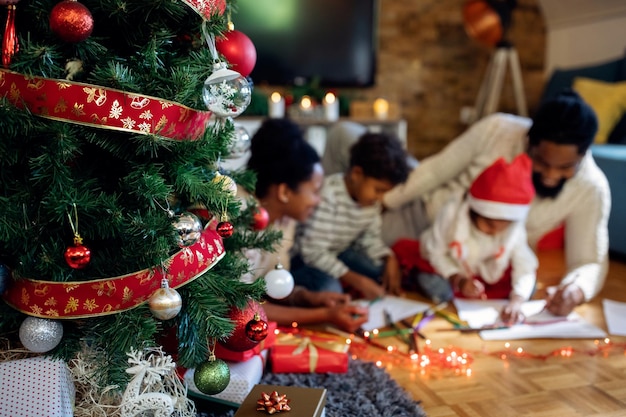 primer plano, de, árbol de navidad, con, familia americana africana, en, el, plano de fondo