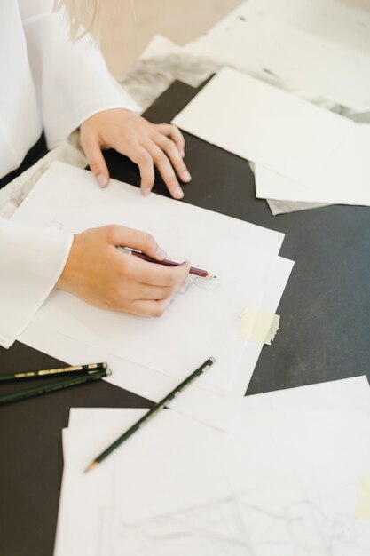 Primer plano de artista femenina dibujar con lápiz sobre papel blanco con lápiz