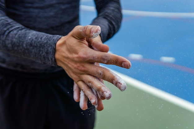 Foto gratuita primer plano de un atleta poniendo tiza en sus manos - concepto deportivo