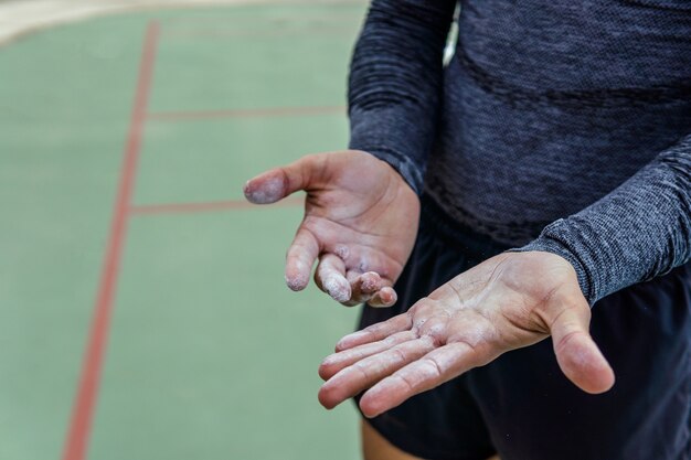 Primer plano de un atleta poniendo tiza en sus manos - concepto deportivo