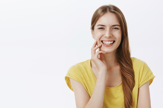 Primer plano de una atractiva mujer despreocupada riendo y sonriendo feliz