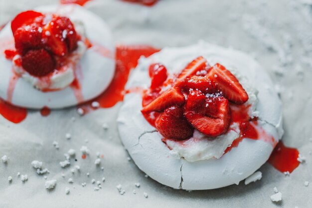 Primer plano de baiser de merengue blanco casero con fresa y mermelada.