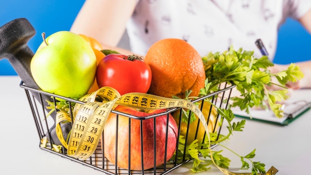 Primer plano de una bandeja con comida de dieta y cinta métrica