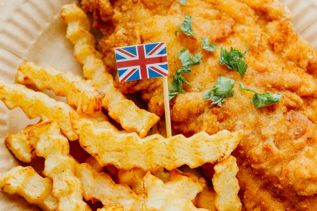 Primer plano de la bandera de Gran Bretaña en plato de pescado y patatas fritas
