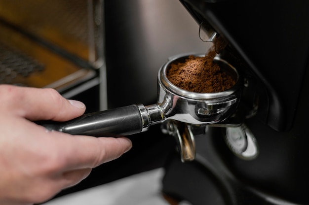 Primer plano de barista masculino con máquina de café profesional