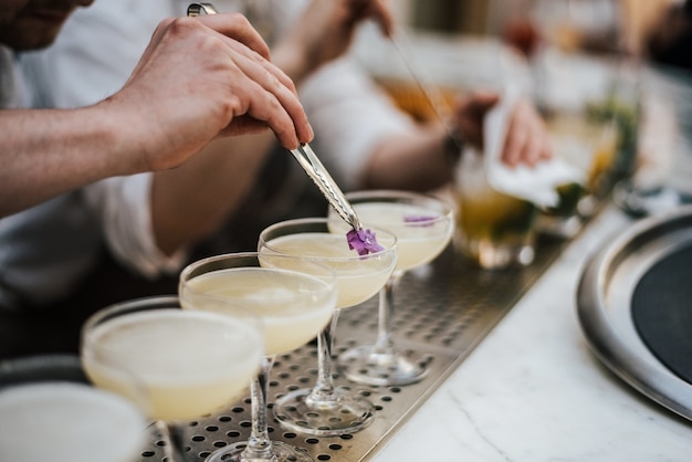 Foto gratuita primer plano de un barman haciendo margaritas con cinco vasos en línea