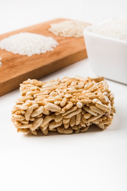 Primer plano de la barra de arroz inflada con arroz blanco crudo contra el fondo blanco