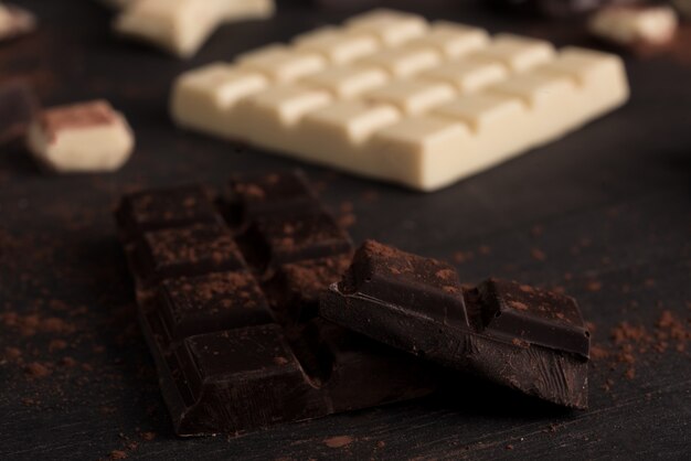 Primer plano de barras de chocolate blanco y oscuro cubiertas de polvo