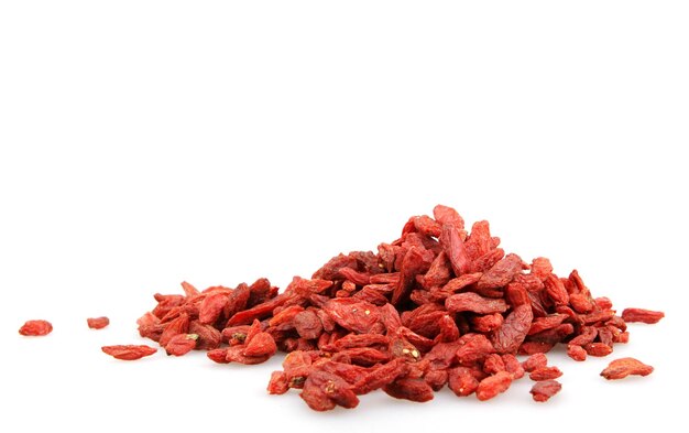 Primer plano de las bayas de goji secas bajo las luces aisladas sobre una superficie blanca