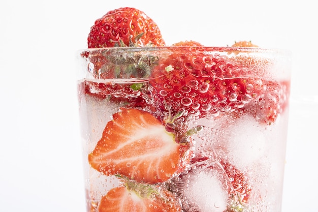 Foto gratuita primer plano de una bebida refrescante con una rodaja de fresas y cubitos de hielo