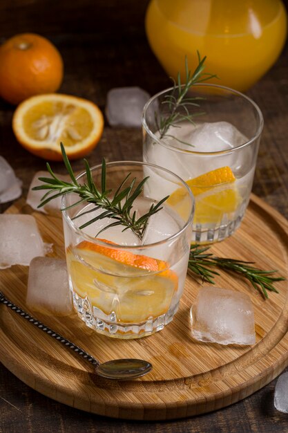 Primer plano de bebidas aromáticas con romero y naranja