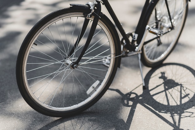 Primer plano de la bicicleta estacionada en la calle en la luz del sol
