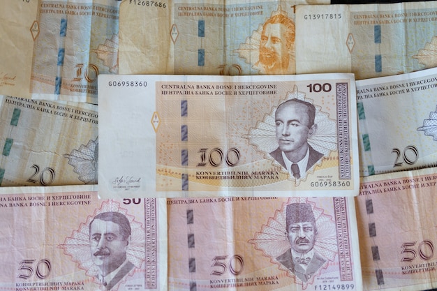 Foto gratuita primer plano de los billetes de bosnia y herzegovina repartidos en la superficie de la moneda