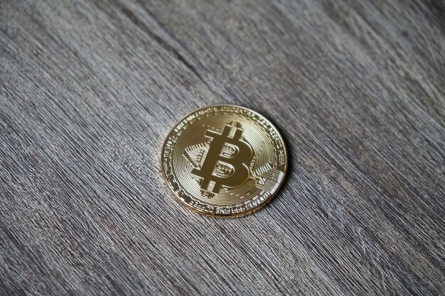 Primer plano de un bitcoin en una mesa de madera