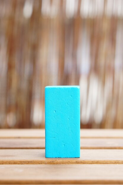 Primer plano de un bloque de juguete de madera azul sobre una superficie de madera