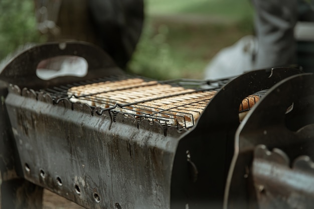 Primer plano de bollos de hot dog fritos en una rejilla a la parrilla.