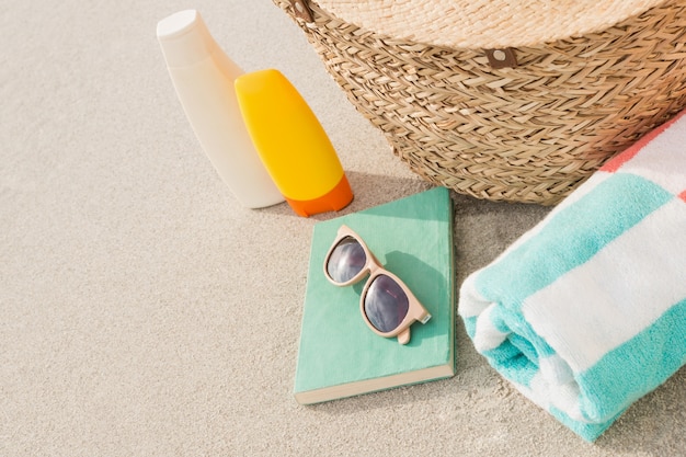 Primer plano de bolsas y accesorios de playa en la arena