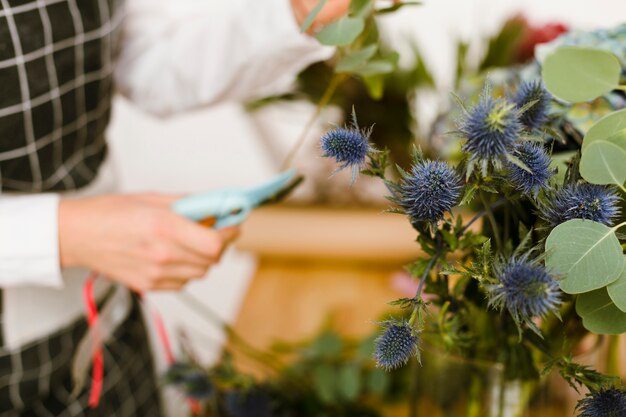 Primer plano borrosa floristería cortando flores para ramo