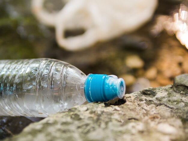 Primer plano de la botella de agua de residuos de plástico en el exterior