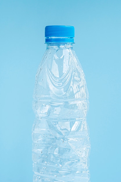 Primer plano de una botella de plástico sobre fondo azul.