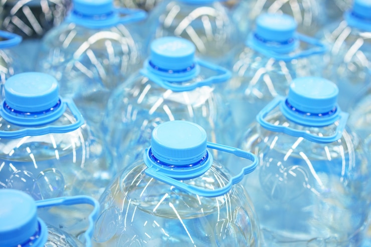 Foto gratuito primer plano de botellas de agua potable de plástico de cinco litros, enfoque suave