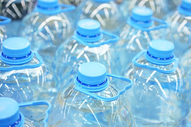 Primer plano de botellas de agua potable de plástico de cinco litros, enfoque suave