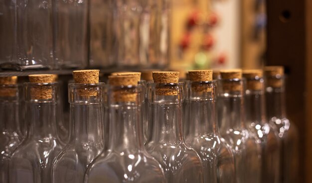 Primer plano de botellas de vidrio vacías con corchos sobre un fondo borroso