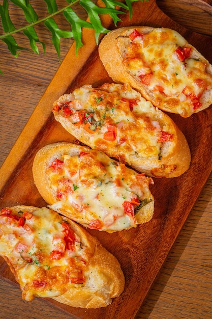 Primer plano de bruschettas de aperitivo italiano con salsa de tomate y queso parmesano en la mesa de madera h