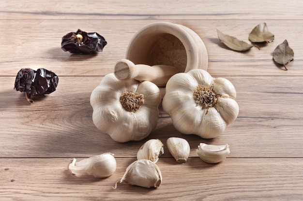 Primer plano de bulbos de ajo y clavo en una mesa de madera